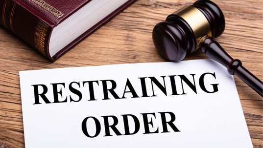 Restraining order legal Document Near Gavel And Law Book Over Wooden Desk